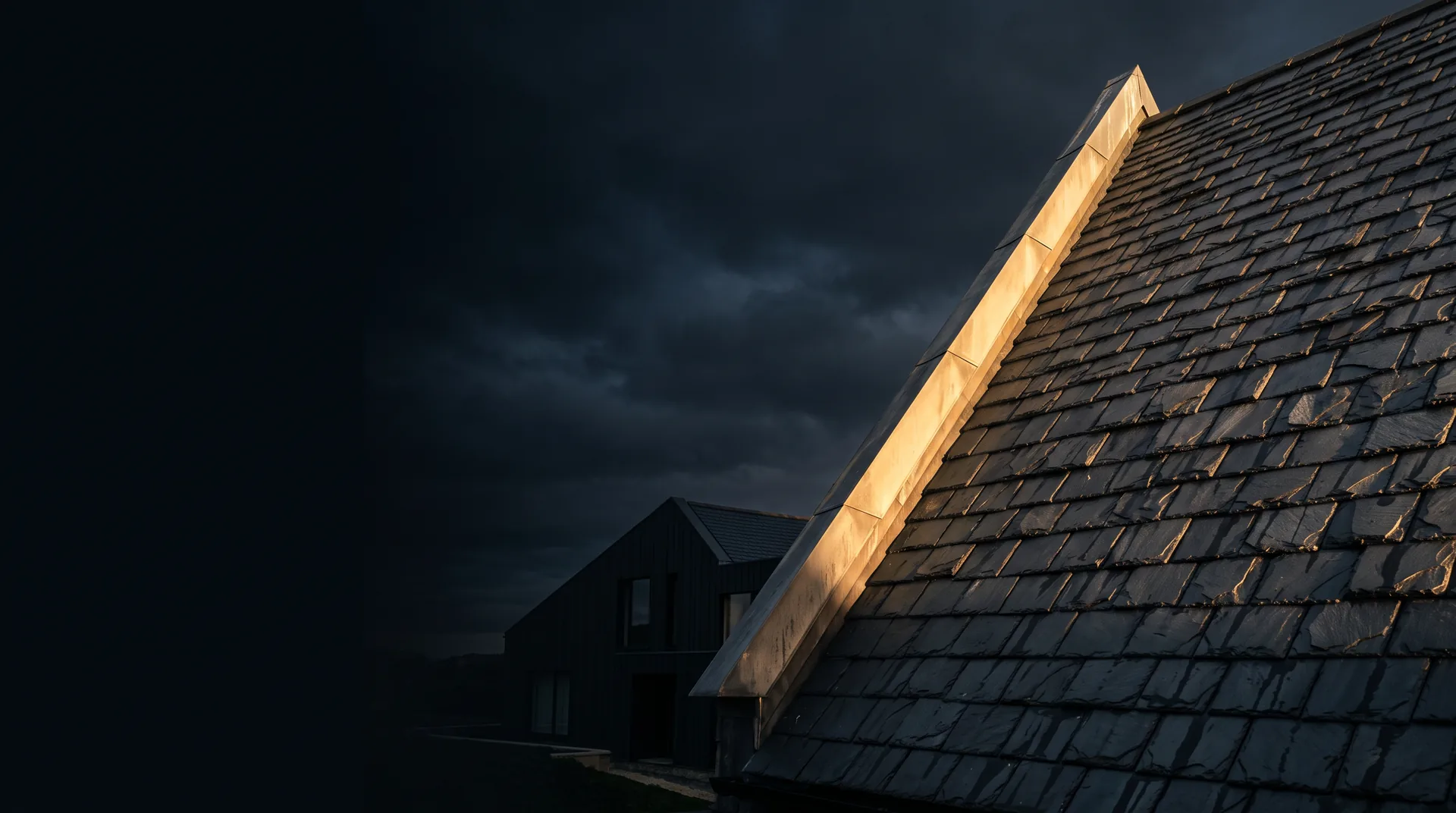Steiles Schieferdach im letzten Abendlicht vor dunklem Himmel